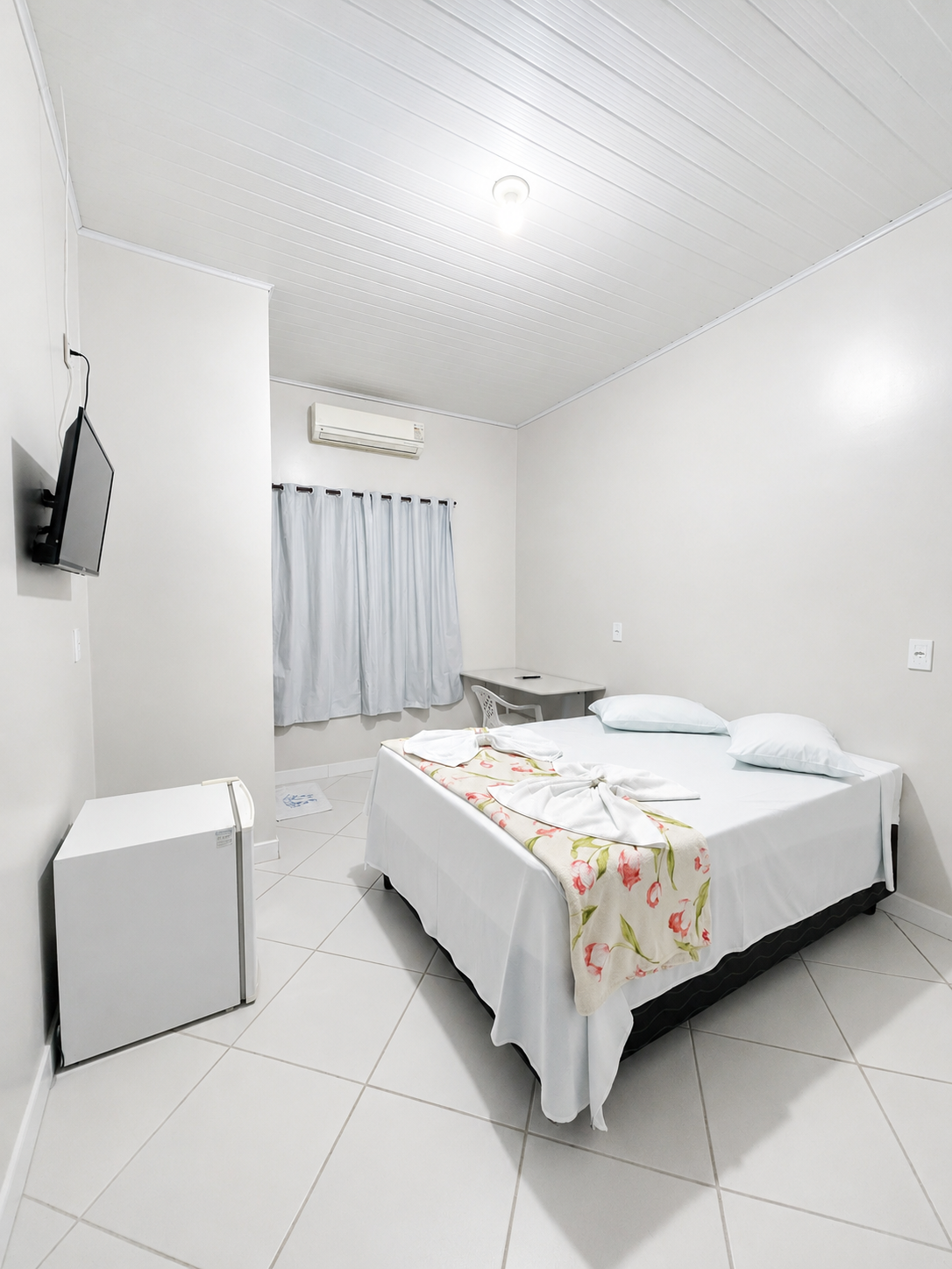 Quarto individual Hotel Verdan — cama de casal com frigobar e mesa de trabalho